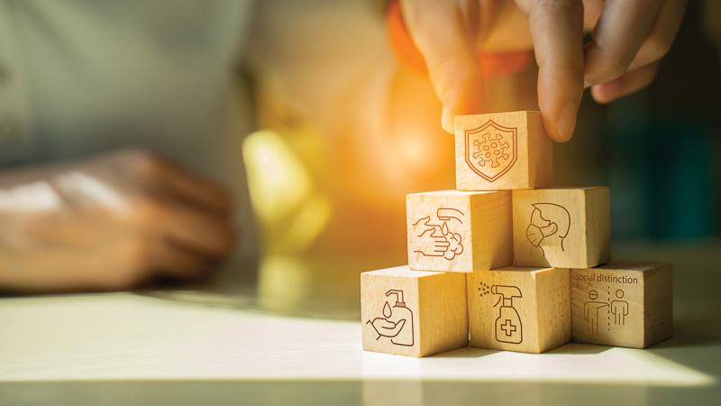 Protect covid-19 concept.hand arranging wood block stacking with Protect covid-19 concept.hand arranging wood block stacking with icon mask,sanitizer gel,Washing hands,social distinction and icon coronavirus(covid-19) in shield of wood cube block on top pyramid.